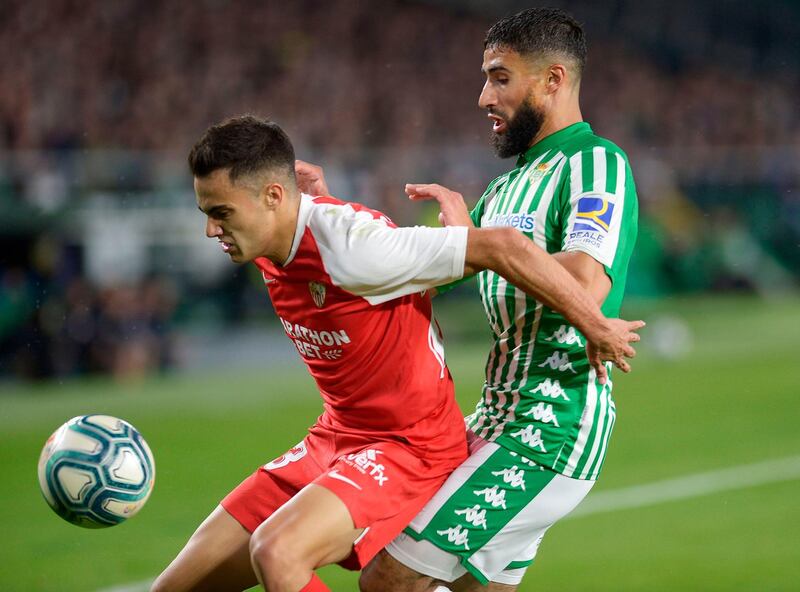 (FILES) In this file photo taken on November 10, 2019 Real Betis' French midfielder Nabil Fekir (R) vies with Sevilla's Spanish defender Sergio Reguilon during the Spanish league football match Real Betis against Sevilla FC at the Benito Villamarin stadium in Seville on November 10, on 2019. The derby between Sevilla and Real Betis will end a 93-day hiatus and launch a five-week sprint to the finish on June 11, 2020. / AFP / CRISTINA QUICLER
