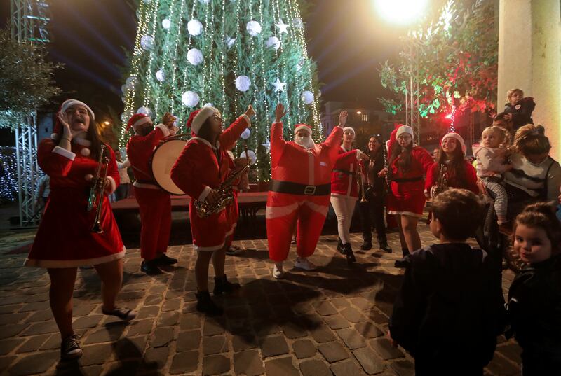 Musicians and other revellers in Santa Claus outfits take part in the Christmas tree lighting ceremony in Byblos. Reuters