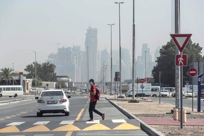 DUBAI, UNITED ARAB EMIRATES. 01 APRIL 2020. A man walks, while wearing a mask, to get to work during the ongoing Stay At Home policy being enforced on a National level in the UAE. With generally mild weather and the general slow down in the use of public transport many commuters are opting to walk distances they would previously have used motorised transport for. (Photo: Antonie Robertson/The National) Journalist: Standalone. Section: National.
. 
