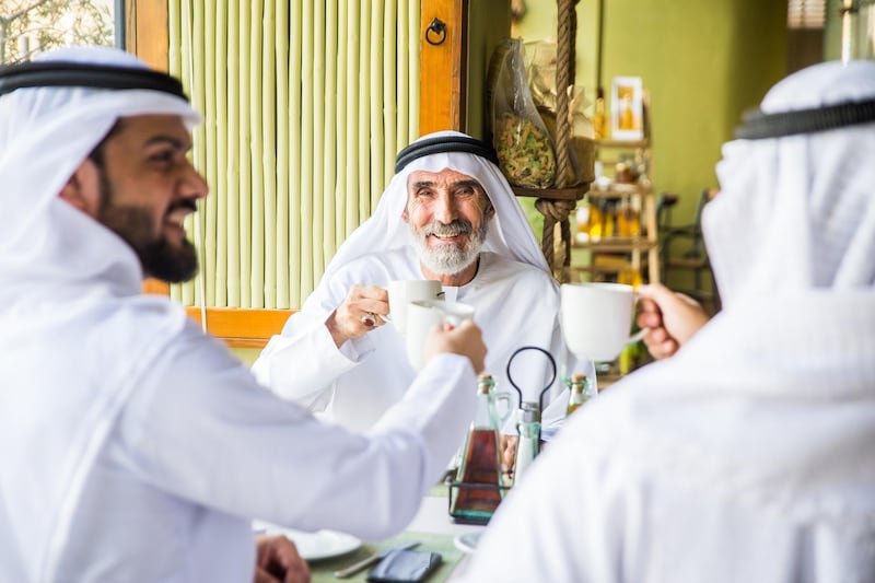 Group of middle eastern men wearing kandora bonding in a cafÃ¨ restarant in Dubai