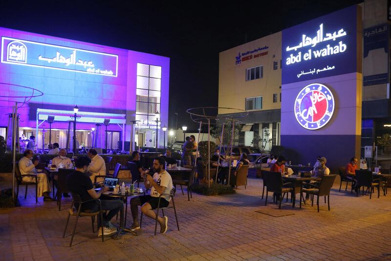People sit at a cafe on Tahlia Street as nightlife returns following the easing of restrictions brought in to stem the spread of the coronavirus, in Riyadh, Saudi Arabia. Reuters