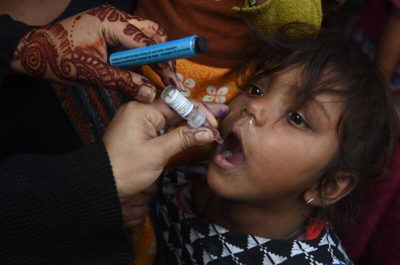 A Pakistani health worker administers polio vaccine drops to a child during a polio vaccination campaign in Lahore on December 11, 2018. Pakistan is one of only two countries in the world where polio remains endemic. / AFP / ARIF ALI
