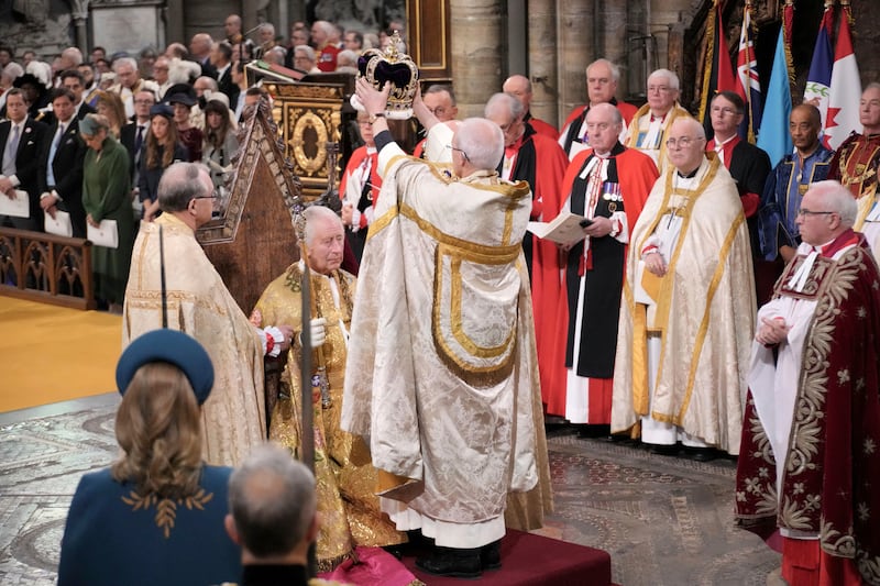 King Charles sits to receive the St Edward's Crown. AP