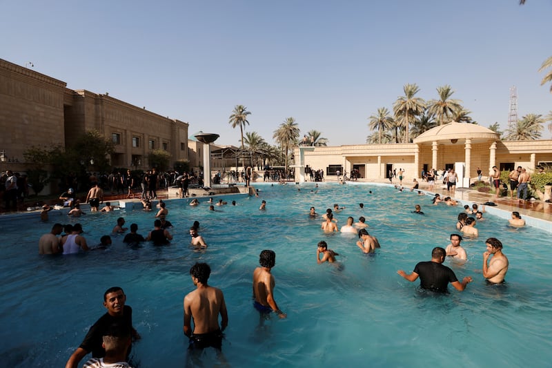Mr Al Sadr's supporters swim amid a protest at the Republican Palace in the Green Zone in Baghdad. Reuters