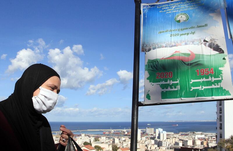A woman walks past posters promoting the vote for the upcoming referendum, Tuesday, Oct.27, 2020 in Algiers. A vote on a new constitution in Algeria will take place on Nov.1, 2020. (AP Photo/Fateh Guidoum)
