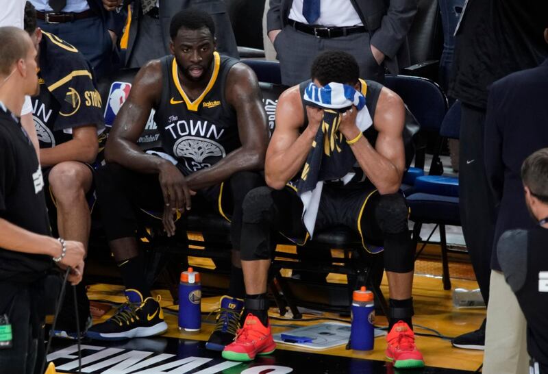 Golden State Warriors forward Draymond Green, left, sits on the bench next to guard Stephen Curry. AP Photo