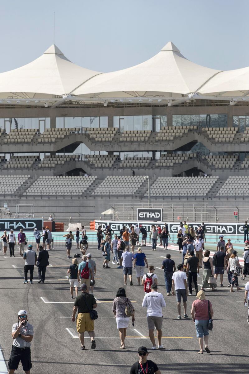 Abu Dhabi, United Arab Emirates, November 23, 2017:    Fans walk through pit lane during previews for the Abu Dhabi Formula One Grand Prix at Yas Marina Circuit in Abu Dhabi on November 23, 2017. Christopher Pike / The National

Reporter: John McAuley, Graham Caygill
Section: Sport