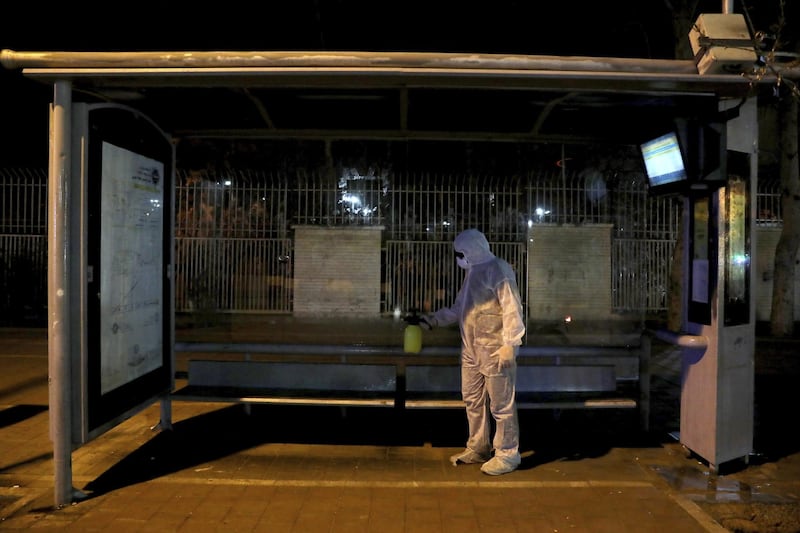 A Revolutionary Guard member disinfects a bus station in Tehran, Iran, March 4. AP