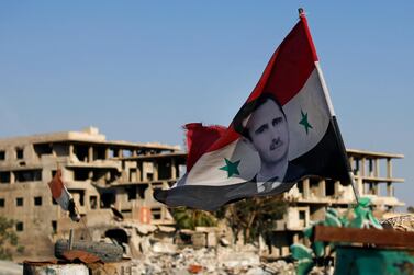 A Syrian flag with a picture of Bashar Al Assad flies in the town of Douma near Damascus on July 15, 2018. AP Photo 