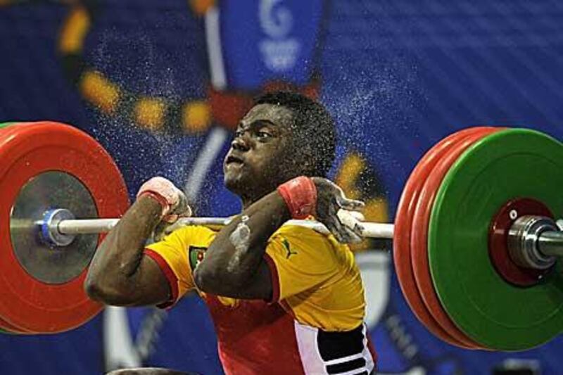 Cameroon’s Petit David Minkoumba attempts a lift during the men’s 77kg weightlifting clean and jerk at the Commonwealth Games.