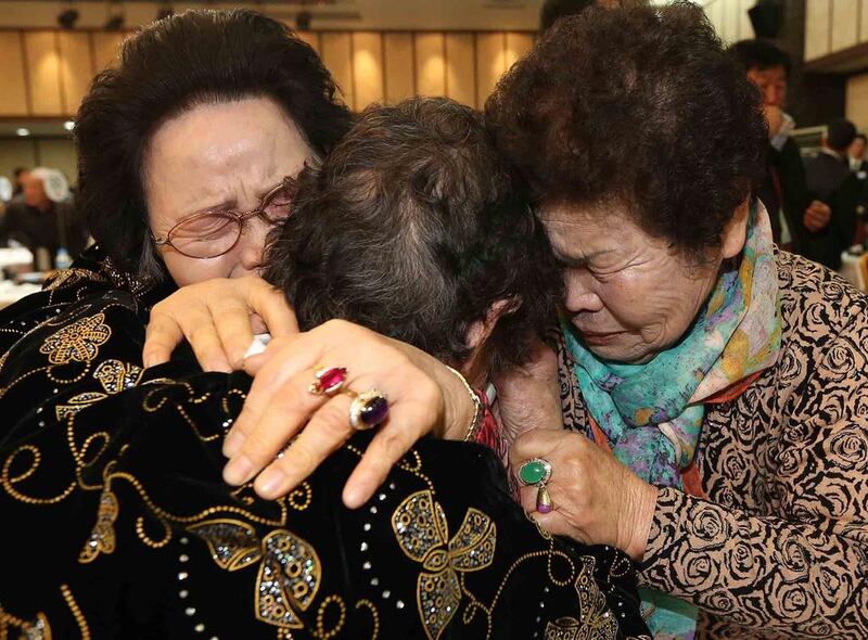 North Korean Kim Tae Un 78, centre, and her South Korean sisters Kim Sa-bun, left, and Kim Young-sun cry as they hug each other during a renion at the Mount Kumgang resort in North Korea on February 23, 2014. A group of South Koreans on Sunday crossed the world's most heavily fortified border, a frontier that separates two countries that remain at war after their conflict ended in an armistice rather than a peace treaty.  Lee Ji-eun/Yonhap / Reuters