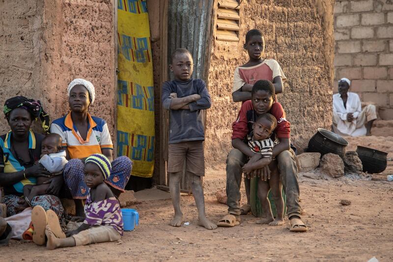 Women and children sit outside a house in a district that welcomes Internally Displaced People (IDP) from northern Burkina Faso in Kaya, on February 2, 2020. - 600 000 Internally Displaced People (IDP) have fled recent attacks in northern Burkina Faso. (Photo by OLYMPIA DE MAISMONT / AFP)