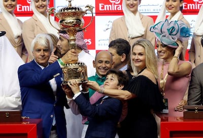 Trainer Bob Baffer, left, and jockey Mike Smith centre, lift the Dubai World Cup at Meydan Racecourse last year. Ahmed Jadallah / Reuters