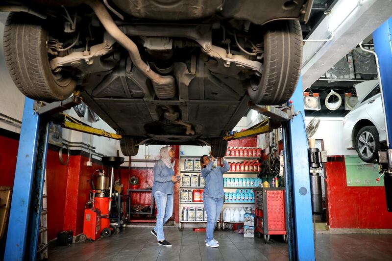 Mechanics Ahlam al Atayyar and Hiba al Juqa check the car of one of their clients in Amman, Jordan.  Reuters