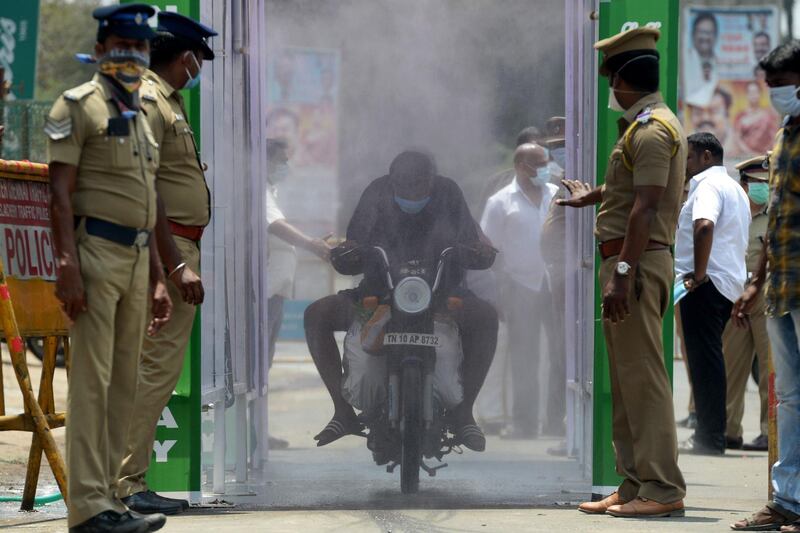 A motorist rides through a disinfection tunnel during a government-imposed nationwide lockdown as a preventive measure against the COVID-19 coronavirus in Chennai.  AFP