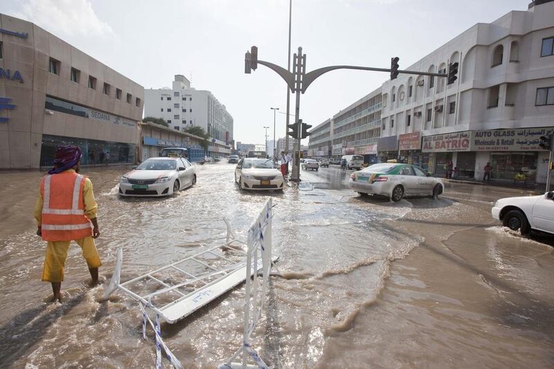 Motorists drive through flooded streets in Sharjah’s Industrial Area 1 last week. Municipality staff worked overtime to clean up most areas, especially at night when there was less traffic, and most roads were cleared successfully. Antonie Robertson / The National 