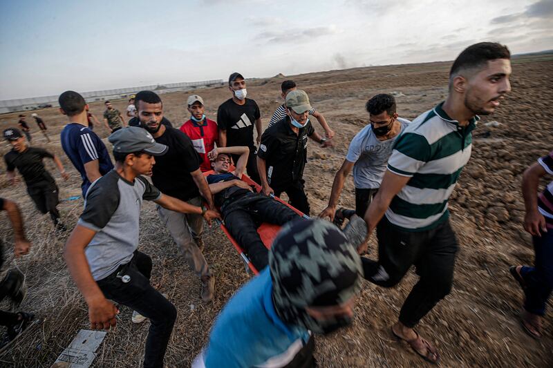 Palestinians carry a protester wounded during clashes with Israeli forces on Friday. EPA
