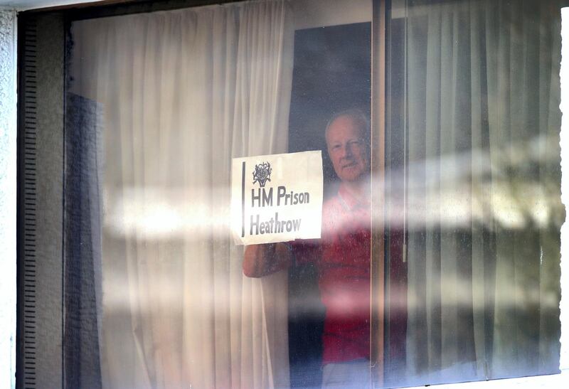 A man holds a sign against a window at the Renaissance London Heathrow Hotel, near Heathrow Airport, London, a Government-designated quarantine hotel being used for travellers to stay during a 10-day quarantine after returning to England from one of 33 "red list" countries. Picture date: Wednesday February 24, 2021. (Photo by Yui Mok/PA Images via Getty Images)