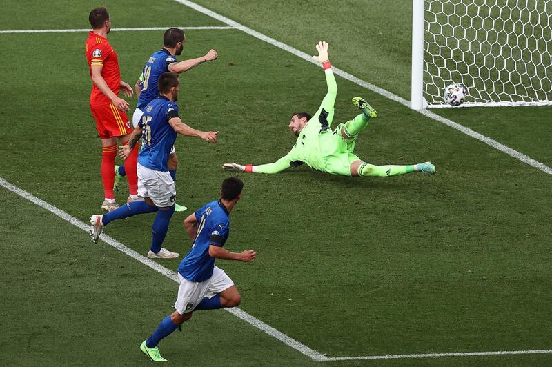 Italy's Matteo Pessina , bottom, wacthes his shot go past Wales goalkeeper Danny Ward and into the net. AFP