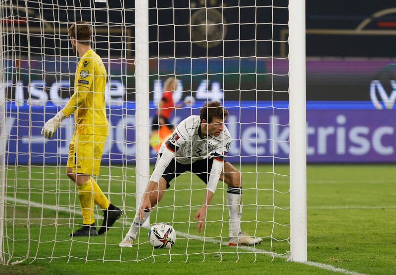 Thomas Muller picks up the ball after scoring Germany's eighth goal in a 9-0 2022 World Cup qualifying win over Liechtenstein, in Wolfsburg, northern Germany, on November 11, 2021. AFP