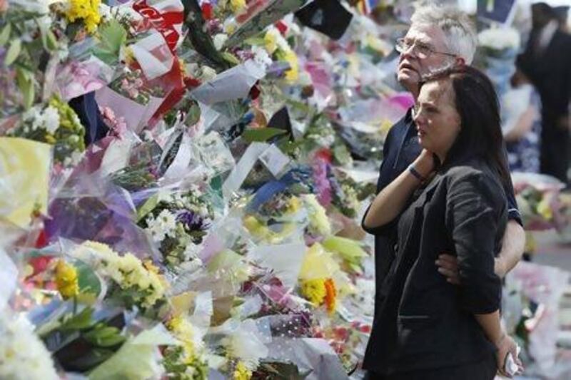 Ian Rigby, (right), the stepfather of murdered British soldier Lee Rigby, and Sarah McClure look at floral tributes left at the scene of his killing in Woolwich.