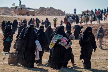 Fully veiled women and children fleeing from the Baghouz area in the eastern Syrian province of Deir Ezzor walk in a field during an operation by the US-backed Syrian Democratic Forces (SDF) to expel hundreds of Islamic State group (IS) members from the region. AFP 