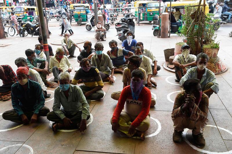 People queue for free meals in front of a charitable restaurant in Ahmedabad. AFP