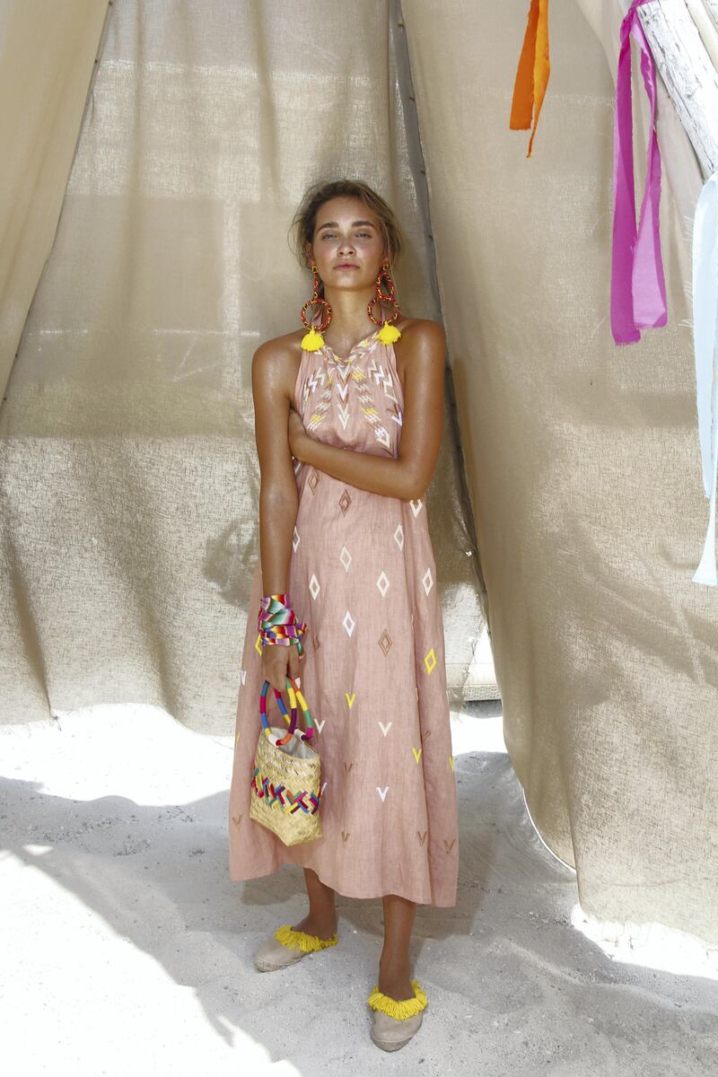 This summer dress features a neutral and feminine palette, speckled with white and yellow embroidery