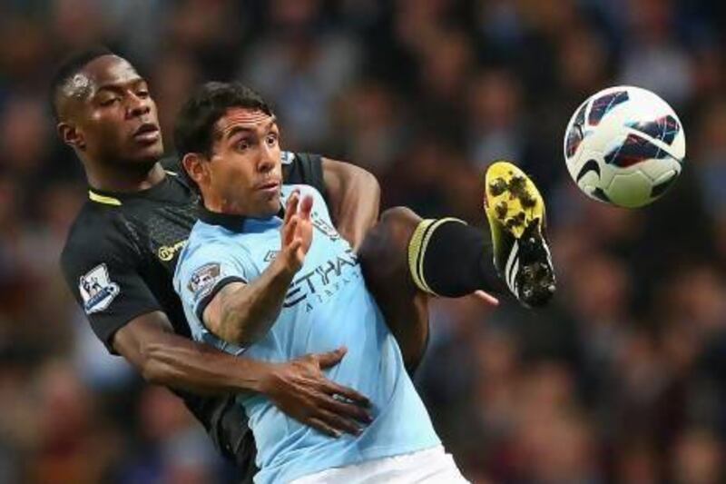 Maynor Figueroa, left, the Wigan defender, attempts to beat Manchester City's Carlos Tevez to the ball at Etihad Stadium. Alex Livesey / Getty Images