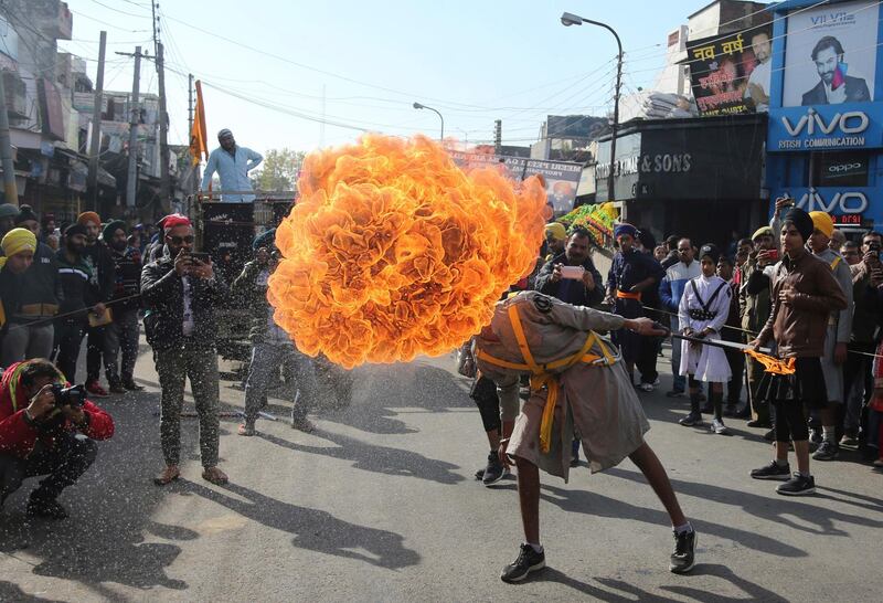 An Indian Sikh warrior blows fire as he displays traditional martial art skills during a religious procession ahead of the birth anniversary of Guru Gobind Singh in Jammu, India. AP Photo