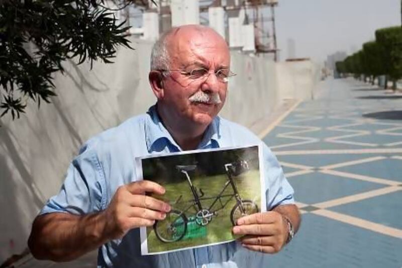 Michael Sayers shows off his distinctive and treasured Moulton AM7 bicycle at the spot on the Corniche where it was taken back in 1992. Silvia Razgova / The National