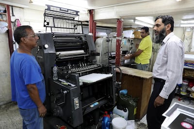 ABU DHABI , UNITED ARAB EMIRATES, September 9 – 2018 :- Naveed Baig ( right ) , manager of the Al Mujahid Printing Press & Stationery with the workers at the press in one of the old building at the Tourist Club area in Abu Dhabi. ( Pawan Singh / The National )  For News. Story by Anna/ John