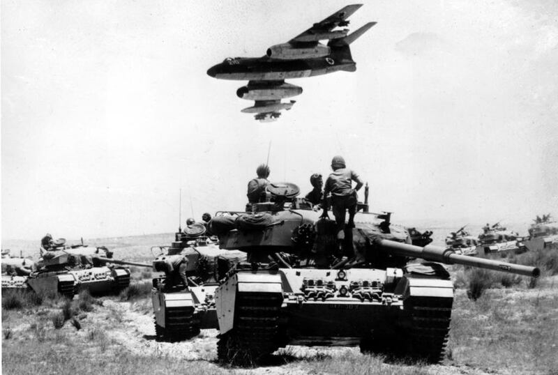 On the front lines of the 1967 war, a French-supplied Israeli bomber flies over a line-up of tanks. (AP Photo)