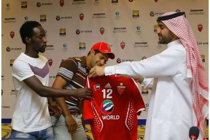 Hosny Abd Rabo, centre, is welcomed by the Al Ahli club chairman Khalifa Saeed Suleiman, right, and the captain Salem Khamis.
