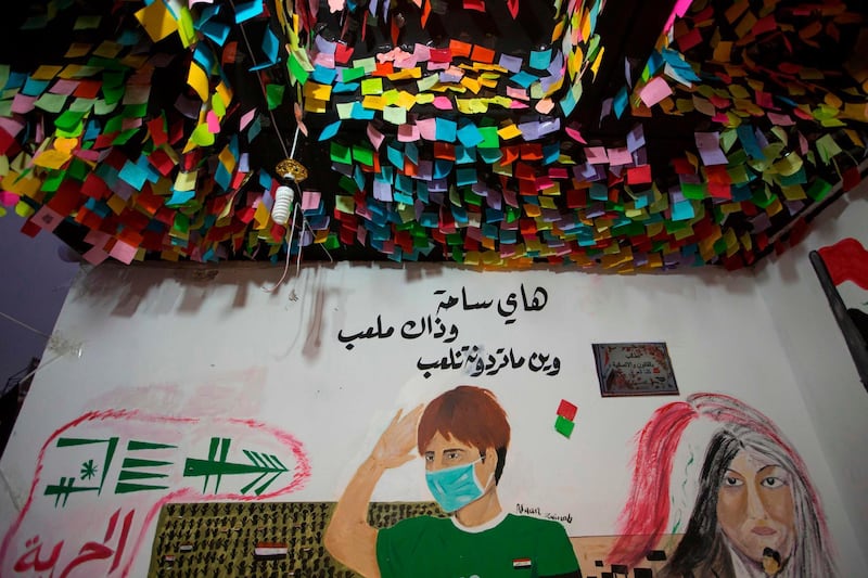 A mural representing an Iraqi pupil saying "this is a public square, and that is a schoolyard...we can play wherever you want", is seen under a canopy of sticky notes in Tahrir Square. AFP