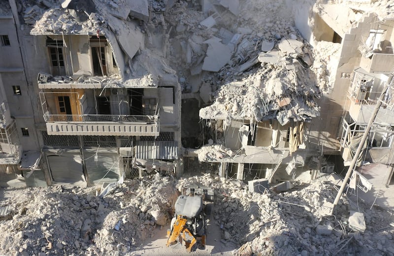 A tractor clears the rubble following Syrian govermnet forces airstrikes in the rebel held neighborhood of Tariq a-Bab in Aleppo on September 24, 2016. - Residents in Syria's battleground city of Aleppo cowered indoors as fierce air strikes toppled buildings and killed at least 52 civilians, after diplomatic efforts to revive a ceasefire failed. (Photo by THAER MOHAMMED / AFP)