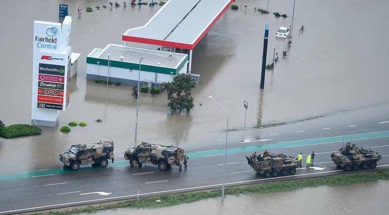 Australian army armoured vehicles can be seen on a  flooded road in Townsville. Getty Images