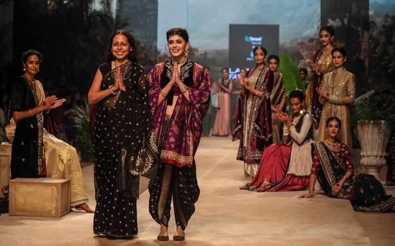 Bollywood actress Sanjana Sanghi (R) presents a creation by Indian designer Anju Modi (L) during the FDCI x Lakme Fashion Week (LFW) in Mumbai, India, 13 October 2022.   EPA / DIVYAKANT SOLANKI 1056