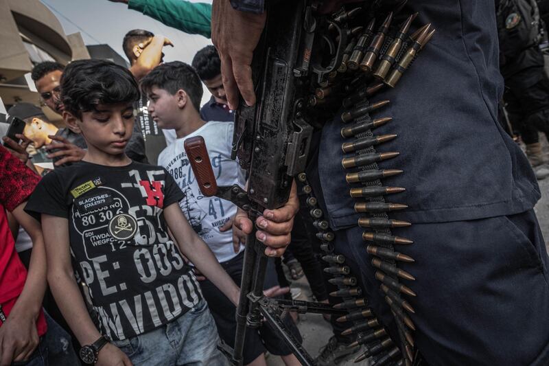A child looks at the gun held by a member of the Ezzedine Al Qassam Brigades, the armed wing of the Palestinian Hamas movement, as a ceasefire came into effect in Gaza City. Getty Images