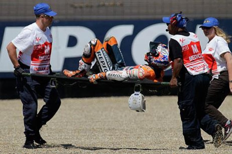 Casey Stoner got up after his crash, then quickly grabbed his right ankle and went right down. The Australian needed help via a stretcher and crew to be moved to the infield medical centre.