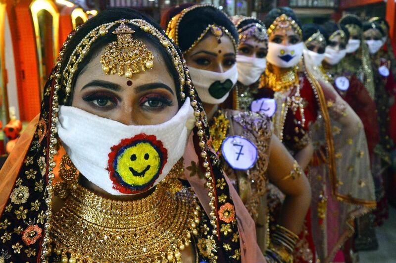 Participants of a beauty contest wearing symbolic masks pose for photographs in Jabalpur, India.  EPA