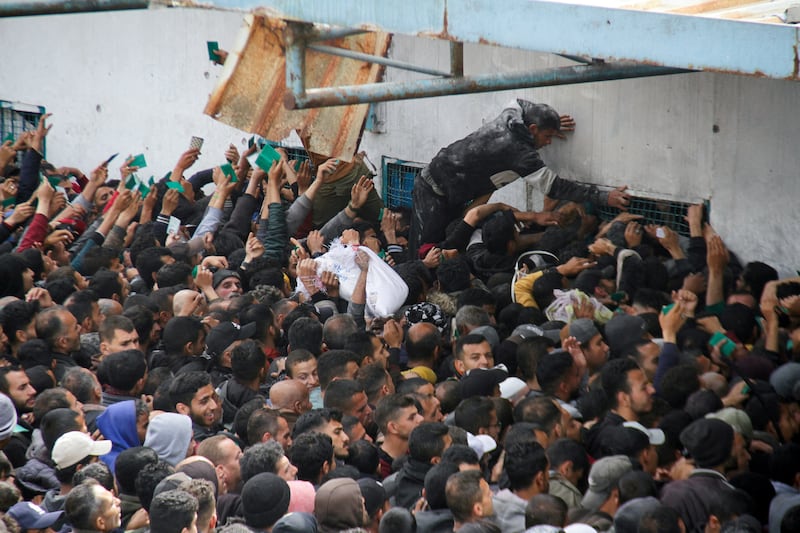 Palestinians gather to receive aid outside a UNRWA warehouse, in March. Reuters