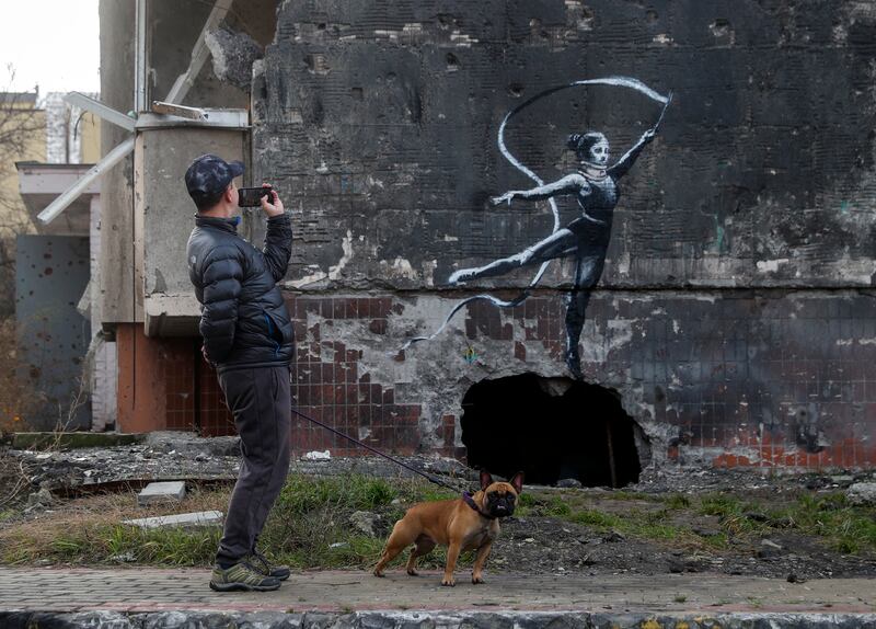 An artistic gymnast on a shelled building in Irpin. EPA