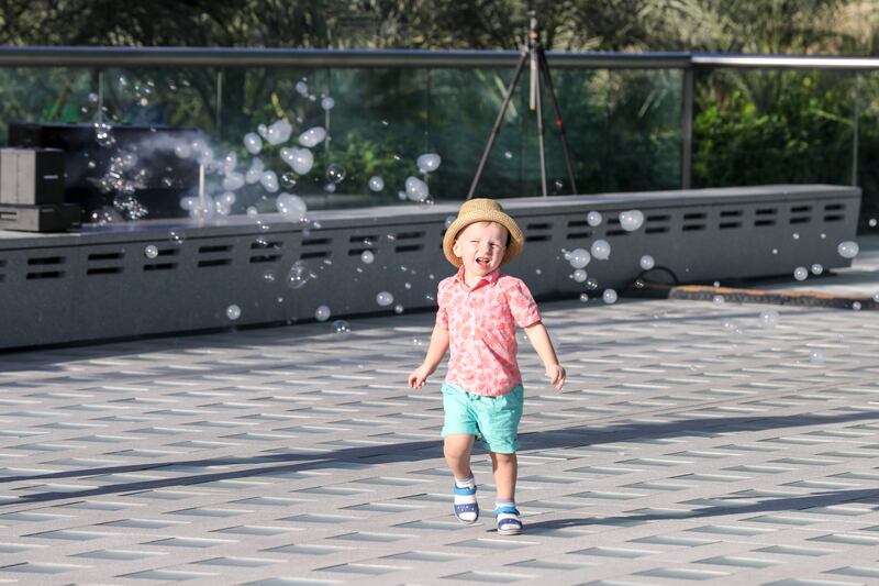 A young boy dancing with bubbles outside Saudi Arabia's pavilion on Friday.