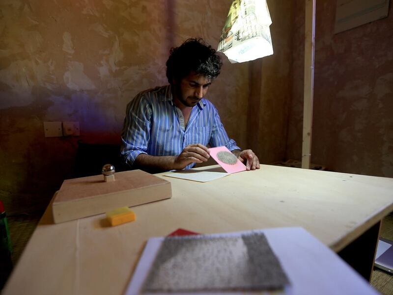 Ghulam Mohammed from Pakistan working on a collage on a paper. Ravindranath L / The National 