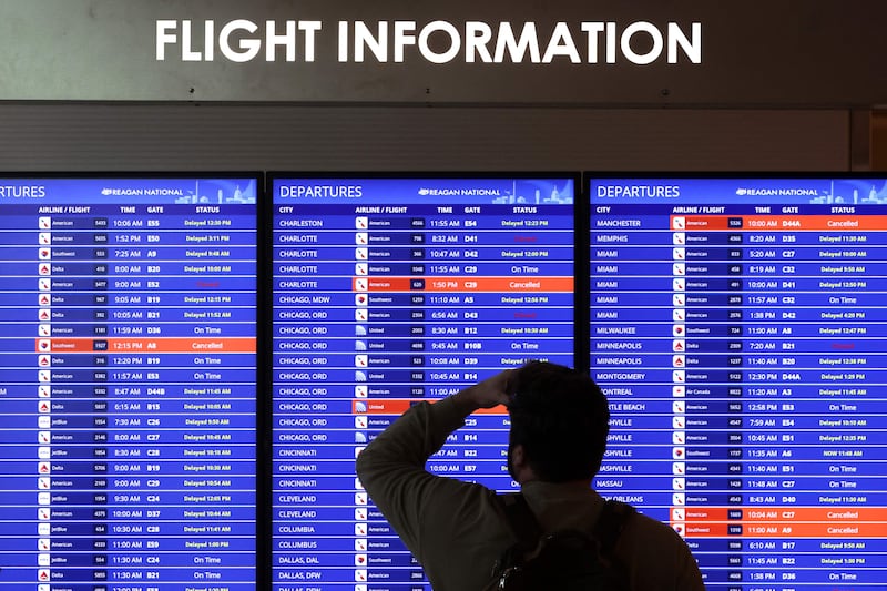 A traveller looks at a flight information board at Ronald Reagan Airport in Virginia. AFP