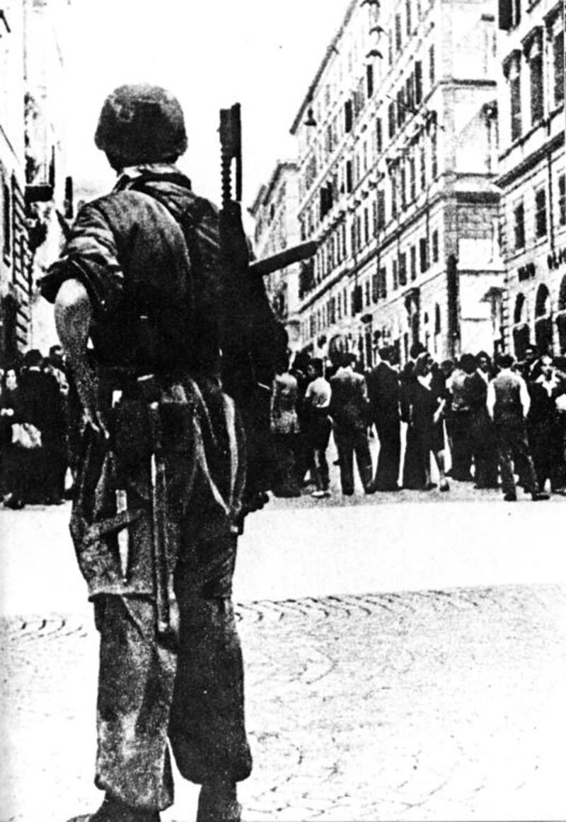 A German paratrooper armed with a submachine gun stands guard over a line of civilians in occupied Rome in 1944. Getty Images