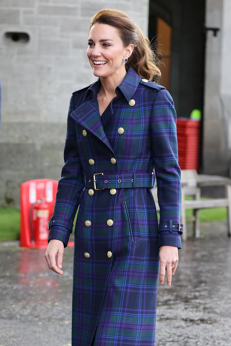 Her hair in a pony tail, the Duchess of Cambridge wears a full-length tartan trench coat to a unique drive-in cinema for a special screening of Disney's Cruella at the Palace of Holyroodhouse in Edinburgh. Chris Jackson/ Reuters