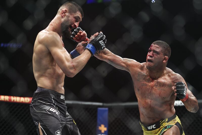 Gilbert Burns punches Khamzat Chimaev during their welterweight bout at UFC 273. AFP