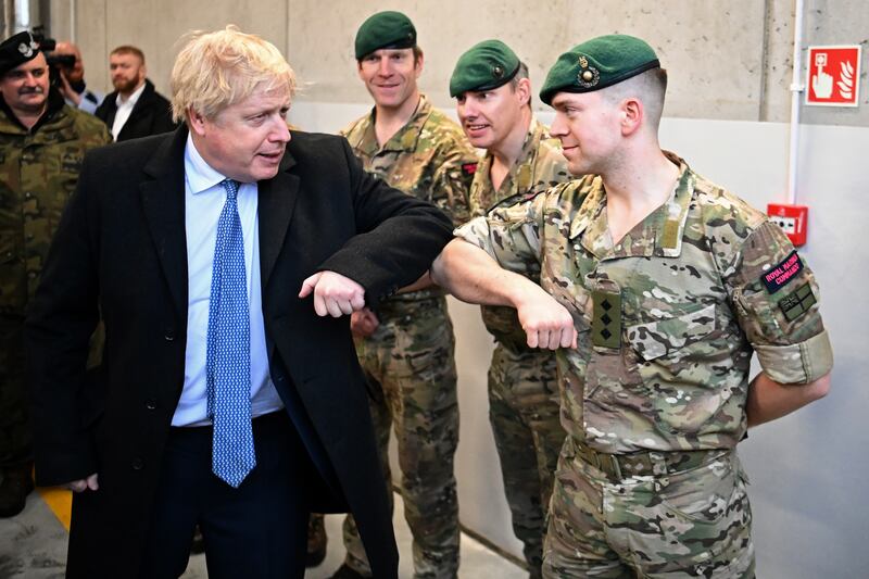 Boris Johnson greets a member of the British Marines during a visit to the base. PA